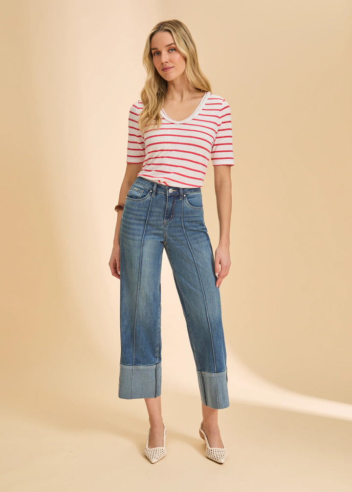 Woman wearing a striped shirt and blue jeans on a beige background