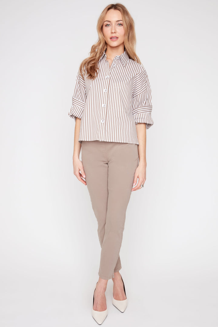 Woman wearing a striped shirt and beige pants on a white background
