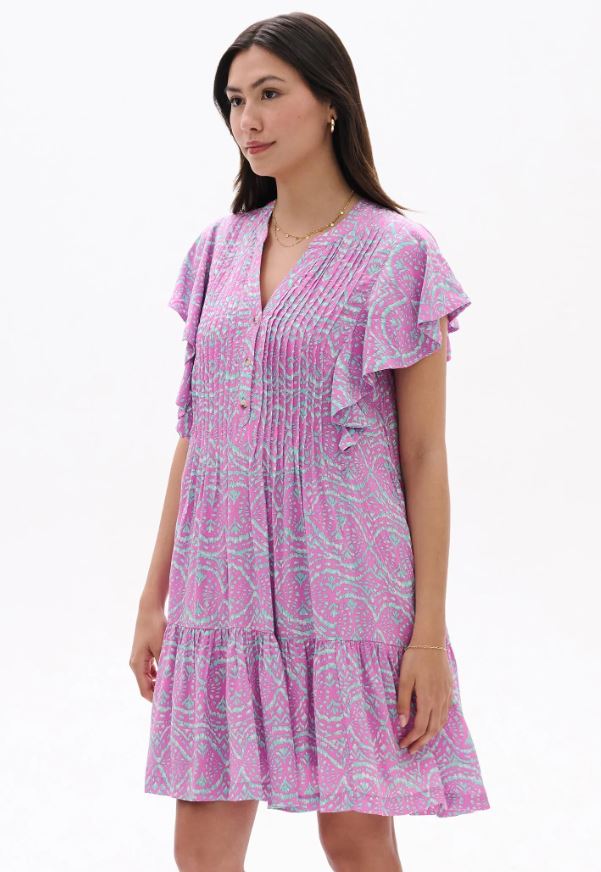 Woman wearing a pink patterned dress on a white background