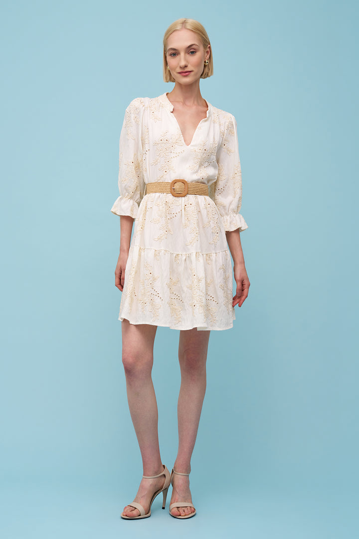 Woman wearing a white dress with a belt on a light blue background
