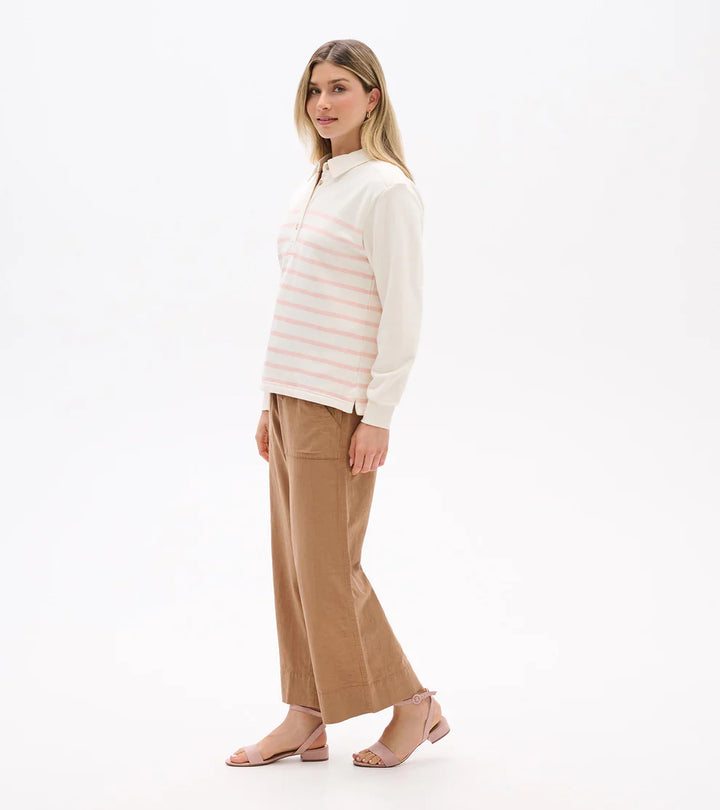 Woman wearing a striped shirt and beige pants on a white background
