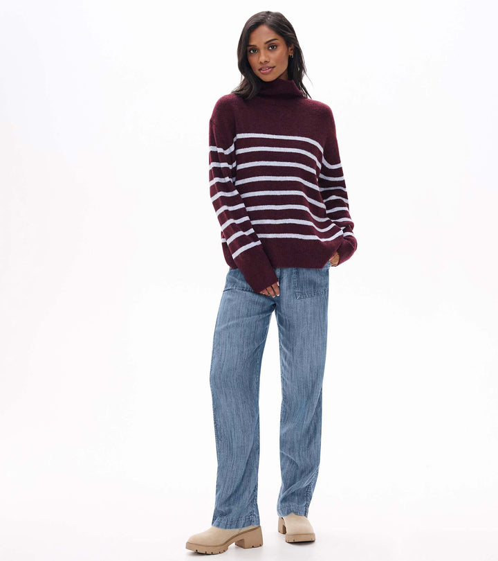 Woman wearing a striped sweater and jeans on a white background