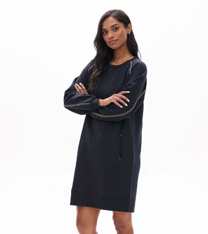 Woman wearing a navy blue dress with a zipper detail on a white background