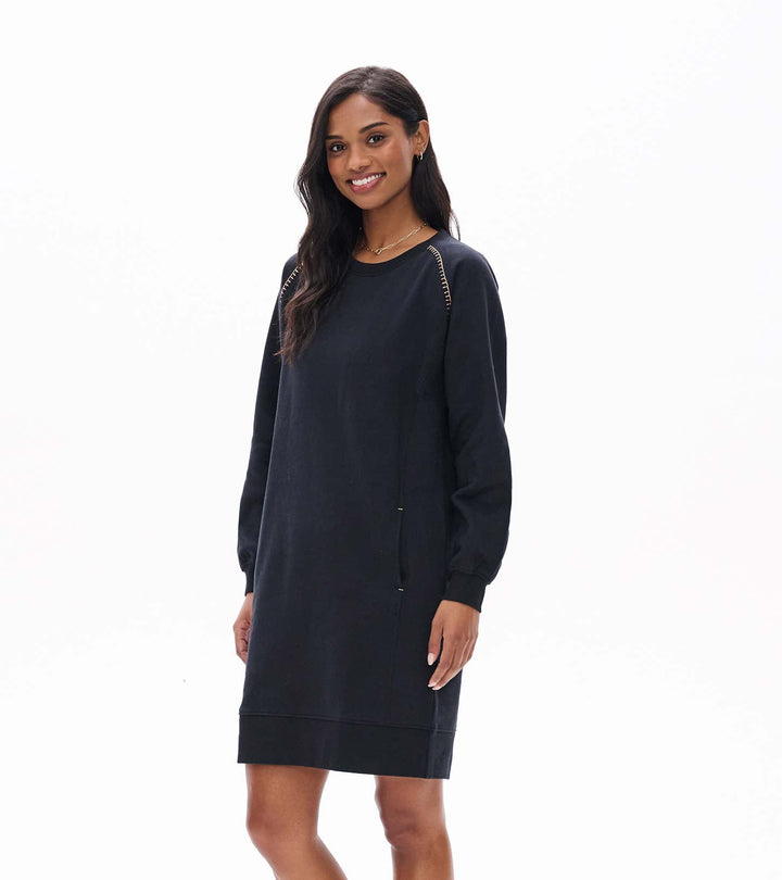 Woman wearing a black dress and brown boots on a white background