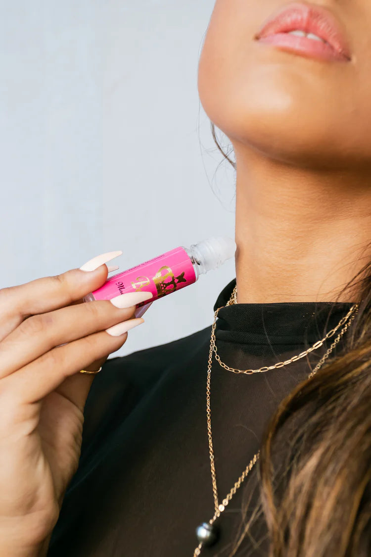 Person holding a pink lip balm with a blurred background