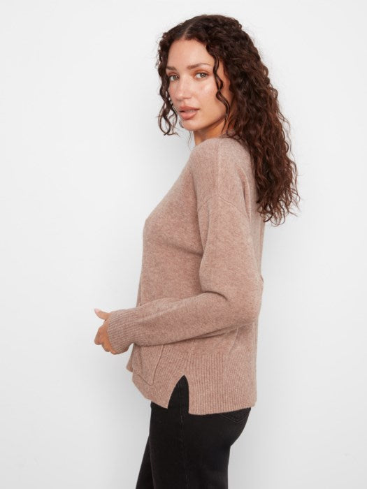 Woman wearing a beige sweater against a white background