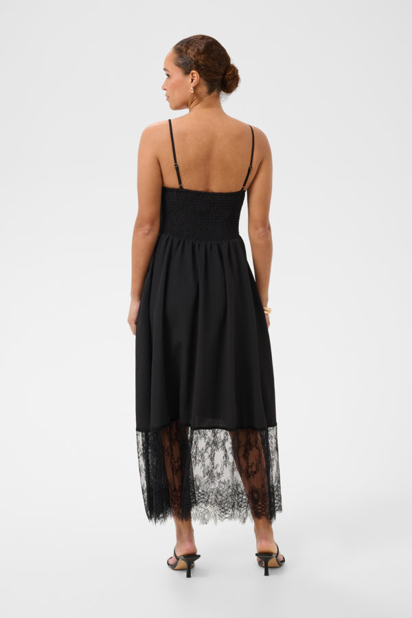 Woman wearing a black dress with lace hem on a white background