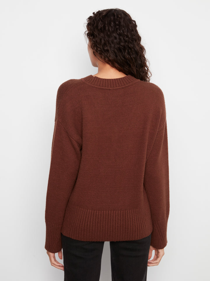 Person wearing a brown sweater on a white background