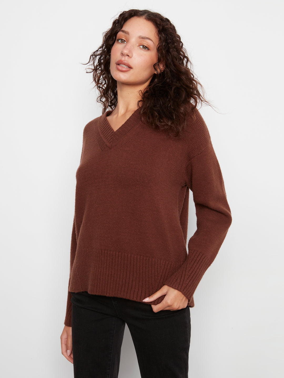 Woman wearing a brown sweater against a white background