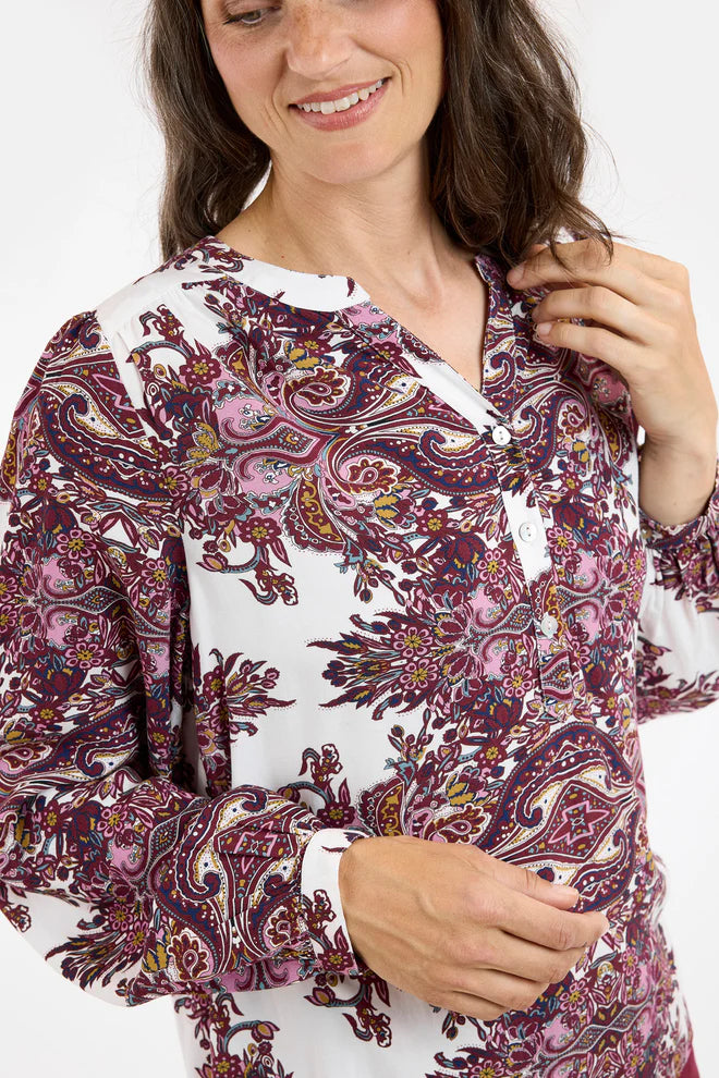 Woman wearing a patterned blouse with a white background
