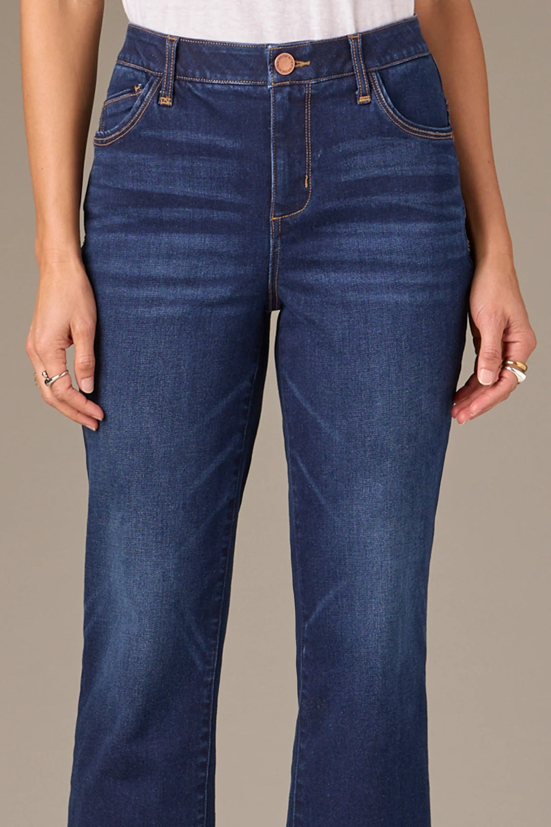 Blue jeans worn by a person on a neutral background