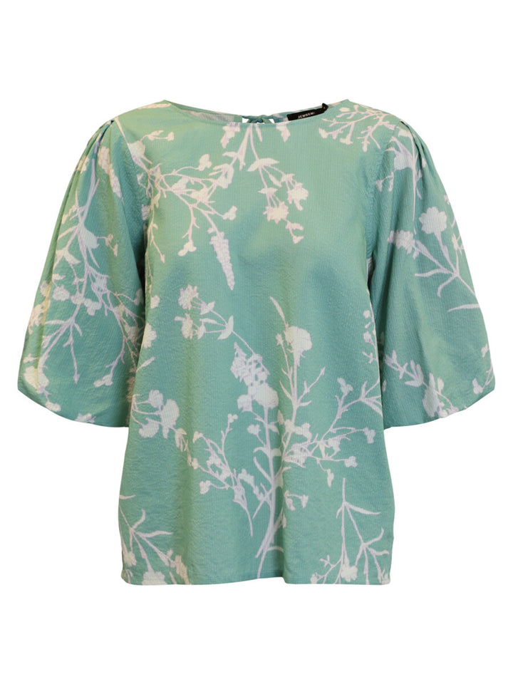Green blouse with floral pattern on a white background