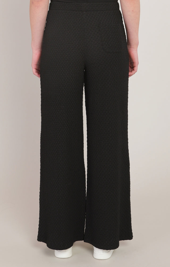 Black textured wide-leg pants worn by a person on a plain background