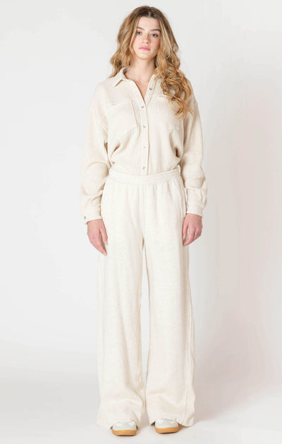 Woman wearing a cream-colored jumpsuit on a white background