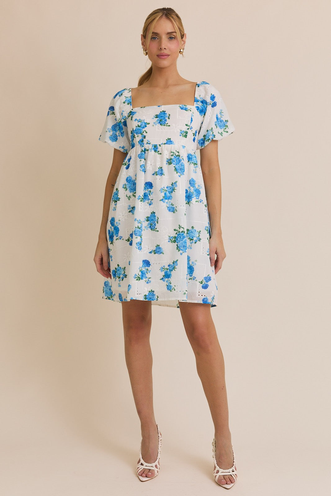 Woman wearing a floral dress with a beige background