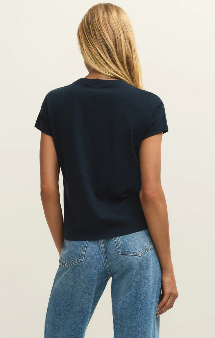 Person wearing a black t-shirt and blue jeans on a plain background