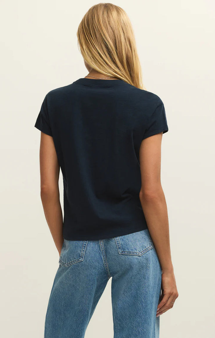 Person wearing a black t-shirt and blue jeans on a plain background