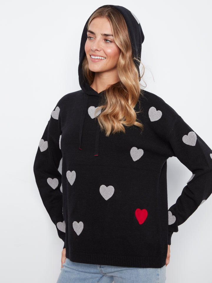 Woman wearing a black hoodie with heart patterns on a white background