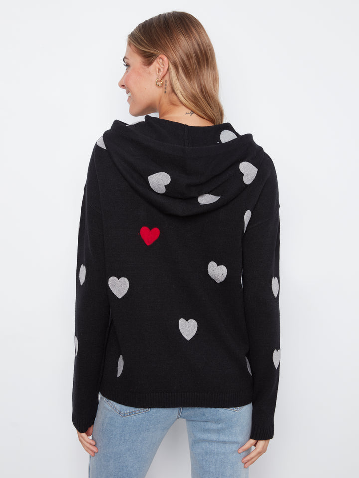 Black hoodie with heart patterns worn by a person on a white background