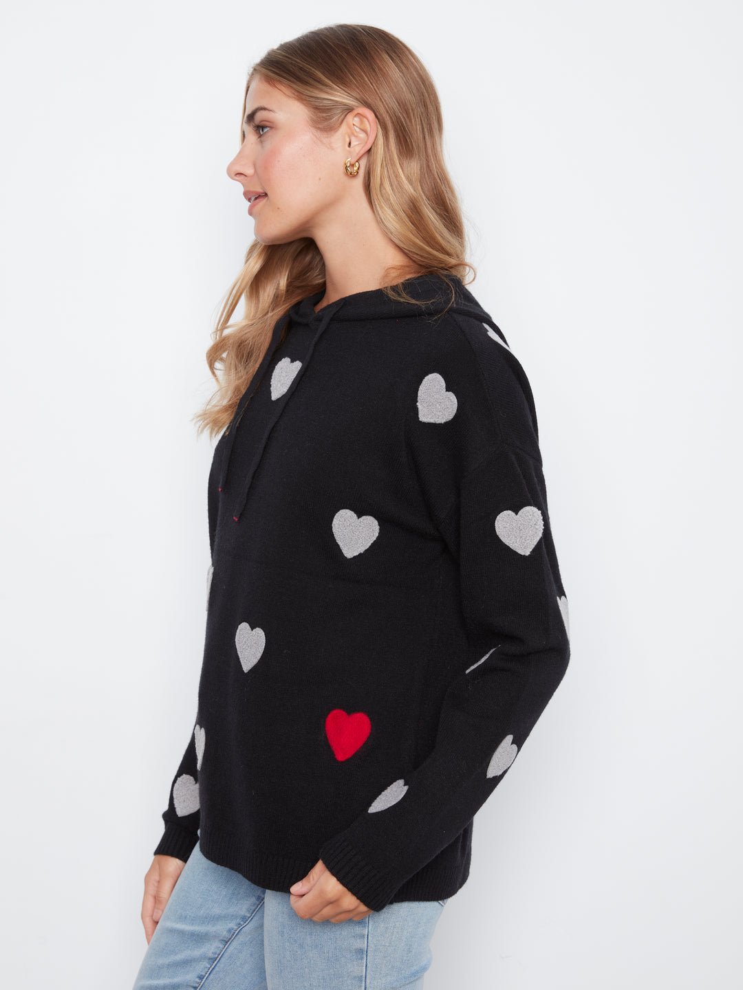 Woman wearing a black hoodie with heart patterns on a white background