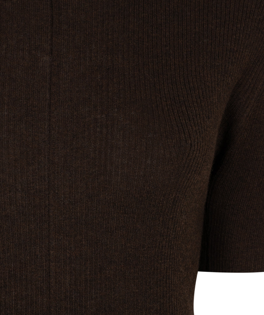 Close-up of a dark brown ribbed knit garment, showing the texture and sleeve detail against a white background.