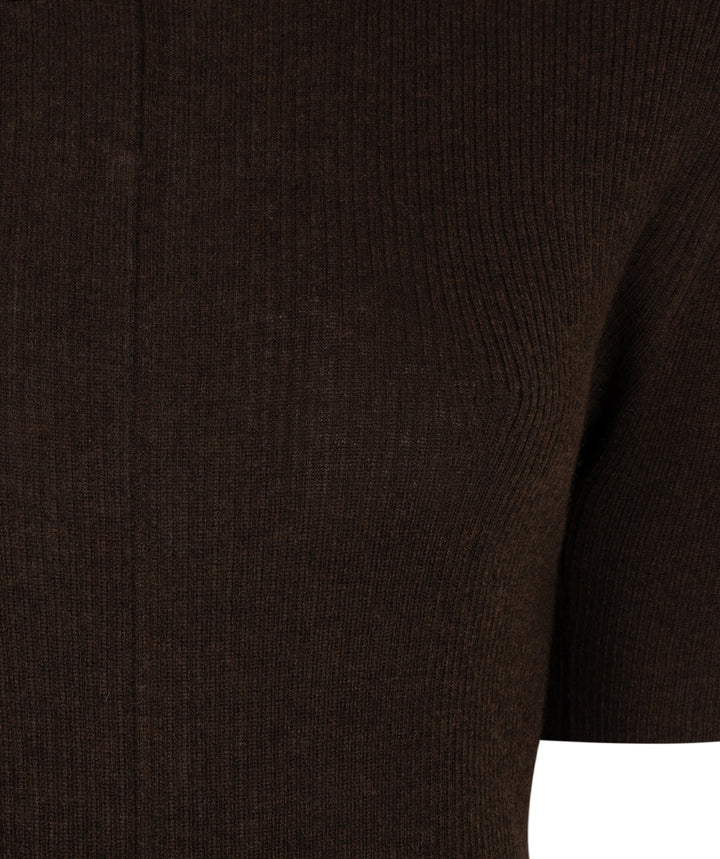 Close-up of a dark brown ribbed knit garment, showing the texture and sleeve detail against a white background.