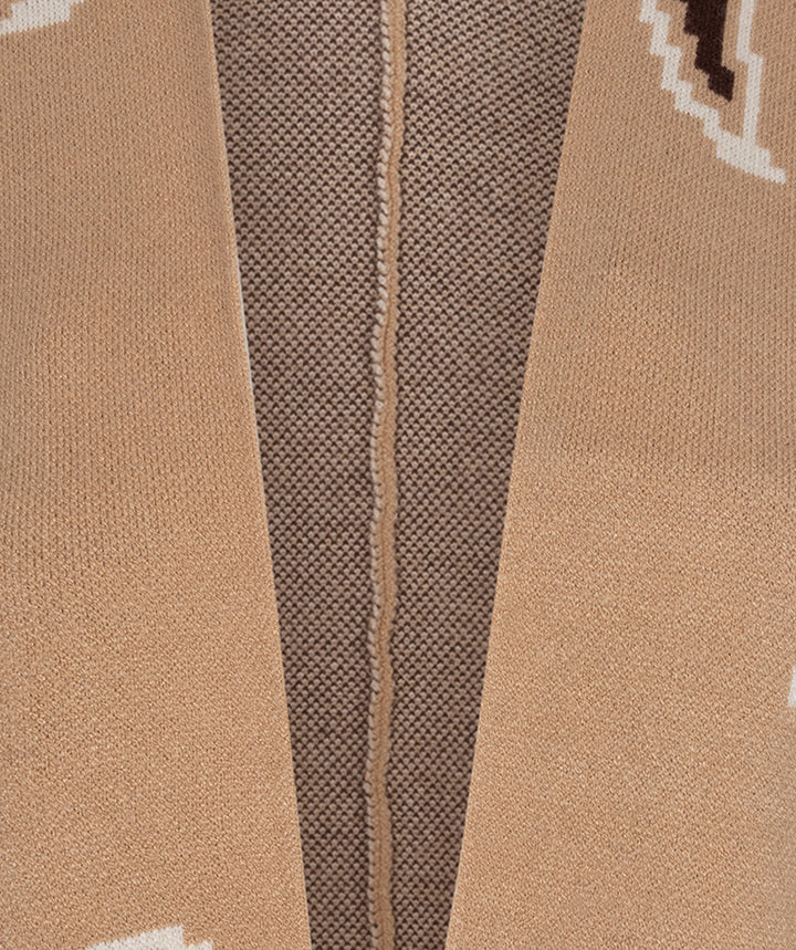 Close-up of a knit garment showing a warm beige outer knit with a central brown textured panel and a thin vertical seam.