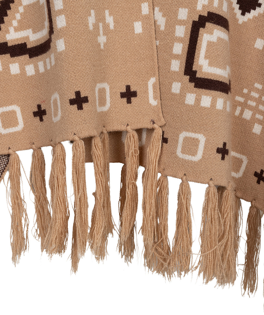 Close-up of a woven throw blanket with fringe, featuring a tan base with geometric patterns in dark brown and off-white.