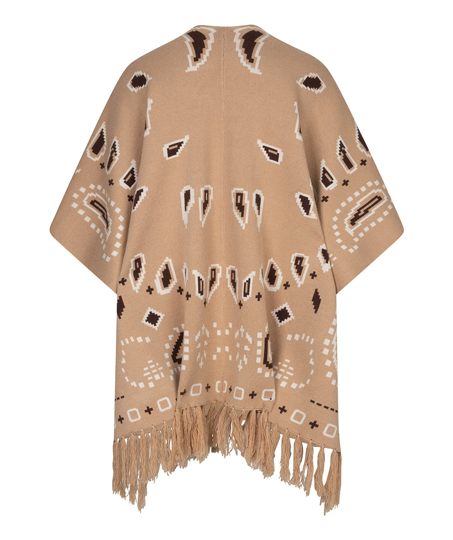 A beige knit poncho with a Southwestern-style geometric pattern in brown and white, featuring a fringed hem, shown against a plain white background.