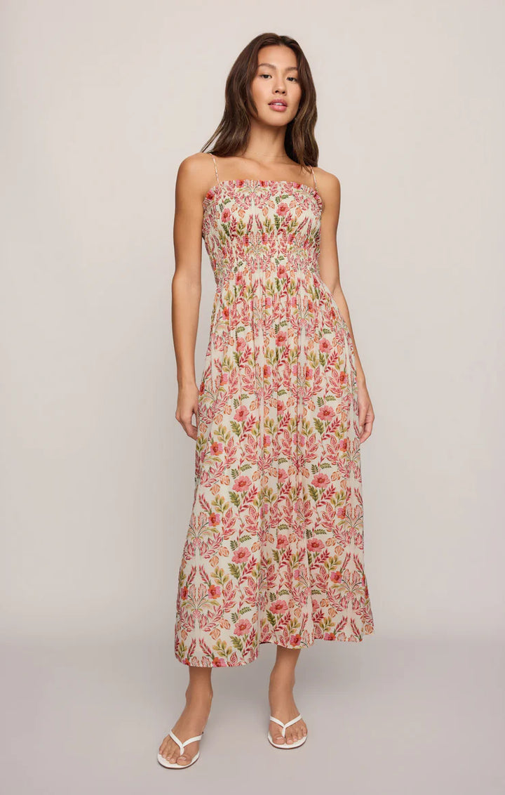 Woman wearing a floral strapless dress on a plain background