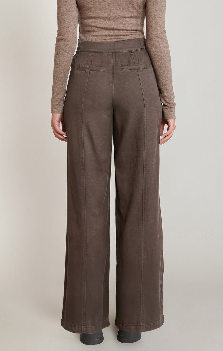Brown pants worn by a person on a plain background