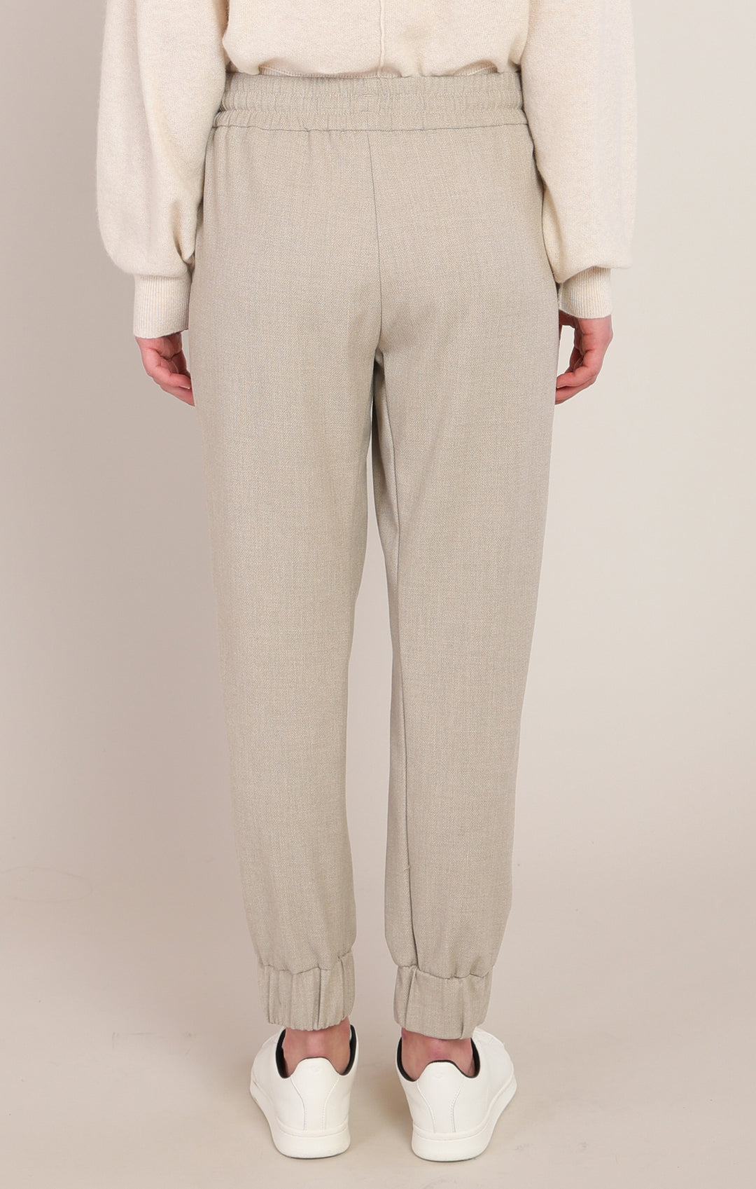 Beige pants worn by a person on a plain background