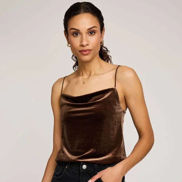 Woman wearing a brown satin camisole against a plain background