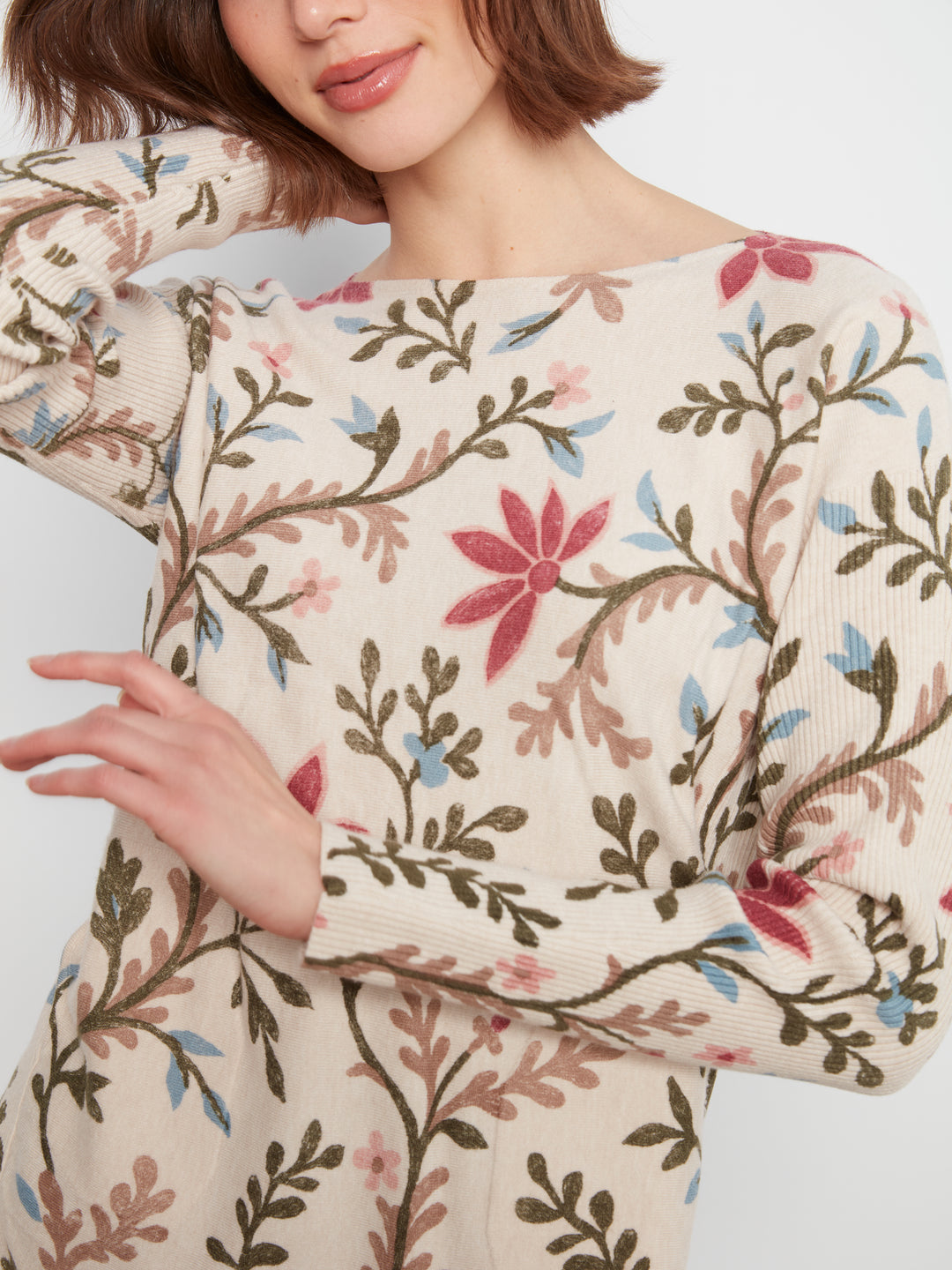 Woman wearing a floral patterned dress with a neutral background