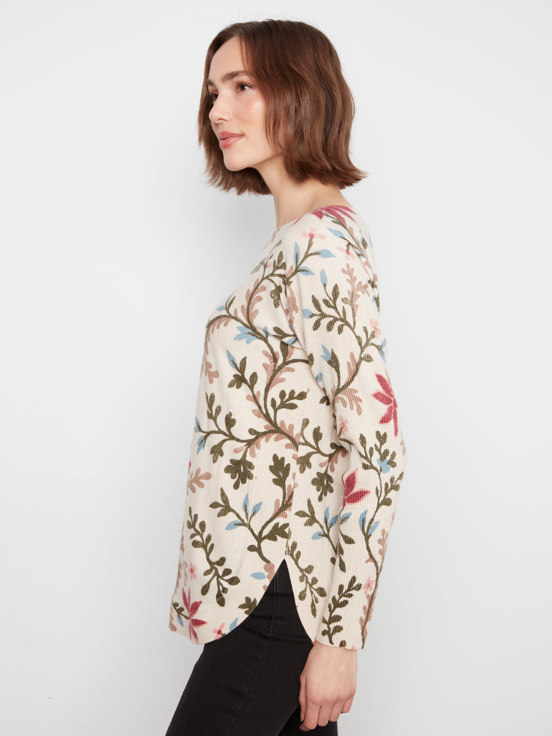 Woman wearing a floral patterned shirt against a white background