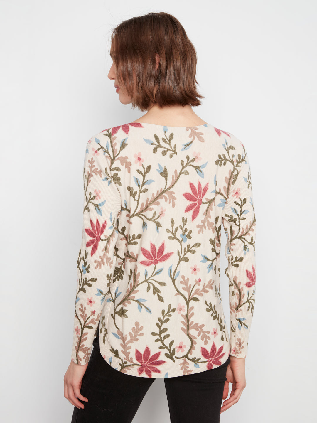 Woman wearing a floral patterned blouse against a white background