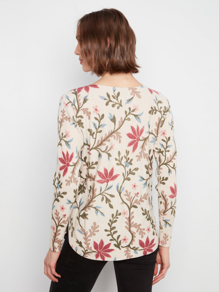 Woman wearing a floral patterned blouse against a white background