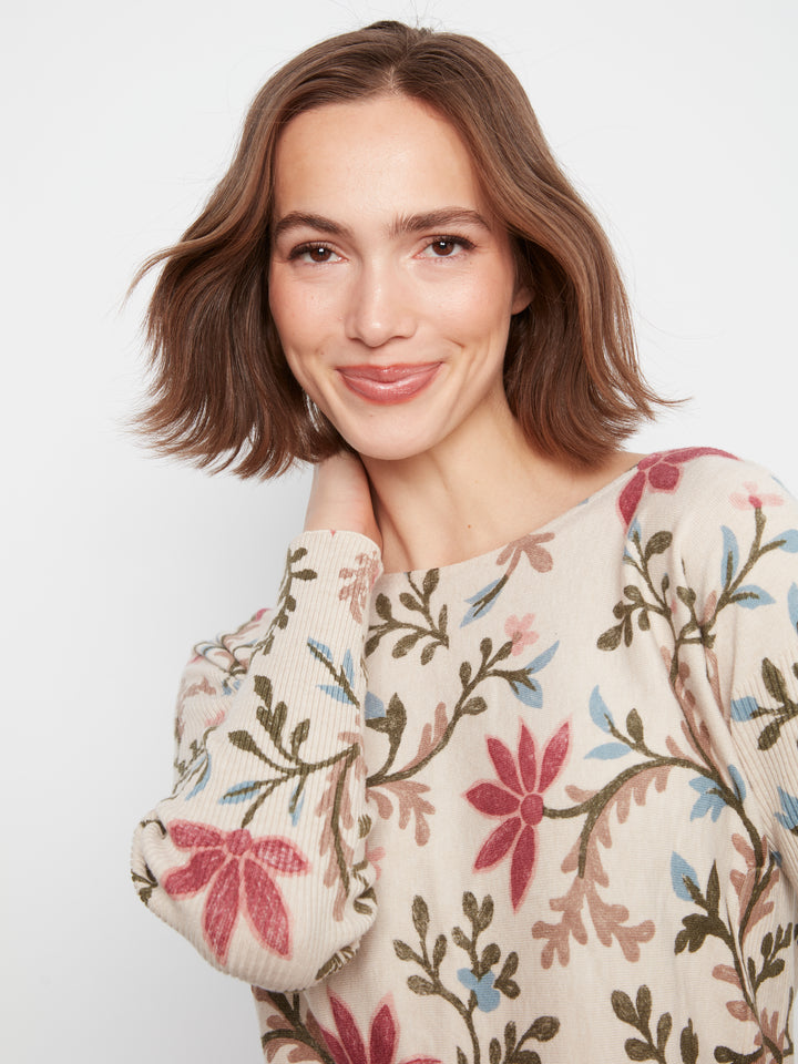 Woman wearing a floral-patterned sweater on a plain background