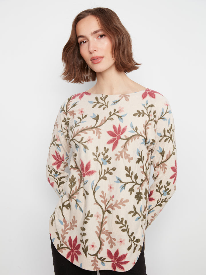 Woman wearing a floral patterned sweater on a plain background