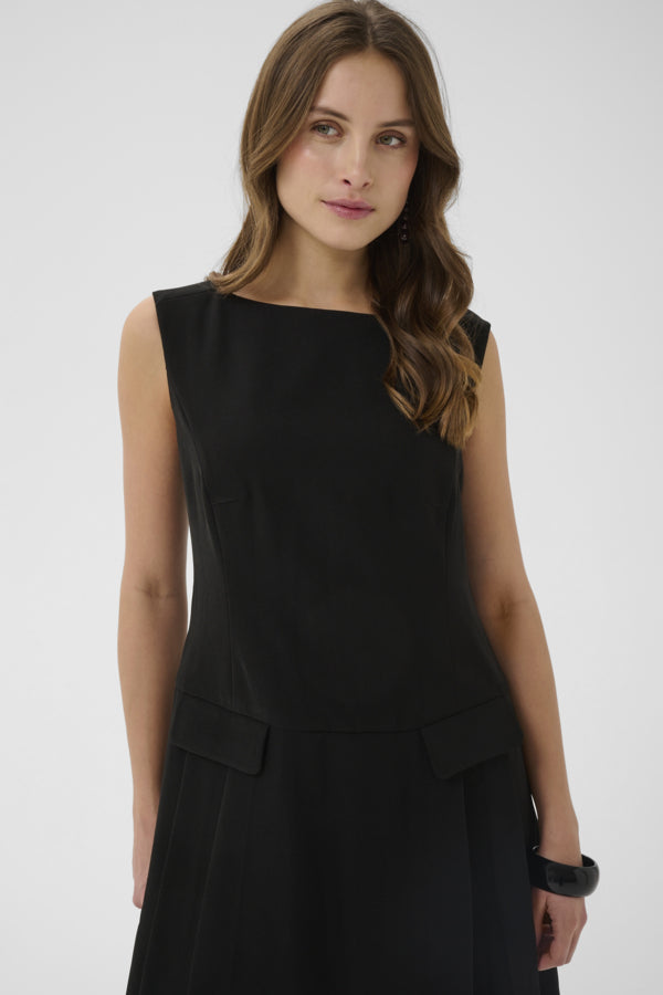 Woman wearing a black sleeveless dress against a white background