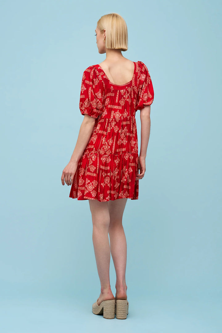 Woman wearing a red dress with puff sleeves on a light blue background