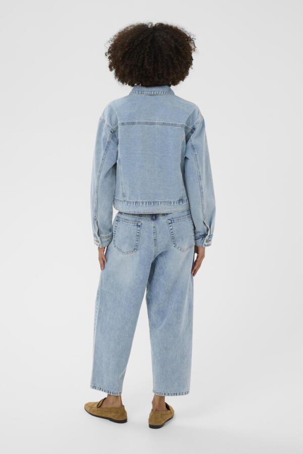 Person wearing a light blue denim jacket and jeans on a white background