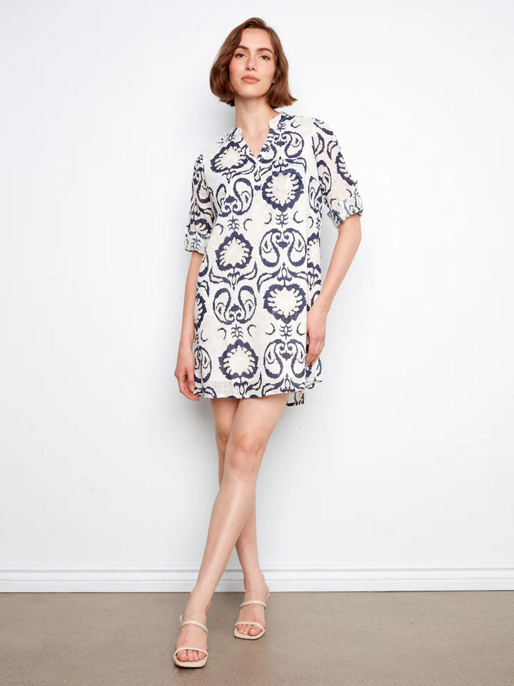 Woman wearing a patterned dress against a white background
