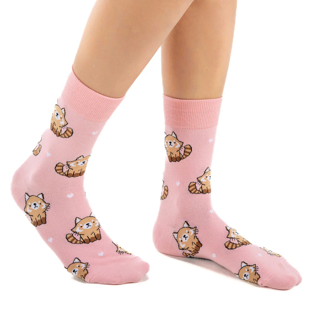 Pink socks with cat pattern worn by a person on a white background