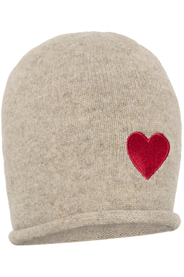 A beige knit beanie hat featuring a red embroidered heart on the side, shown against a plain white background.
