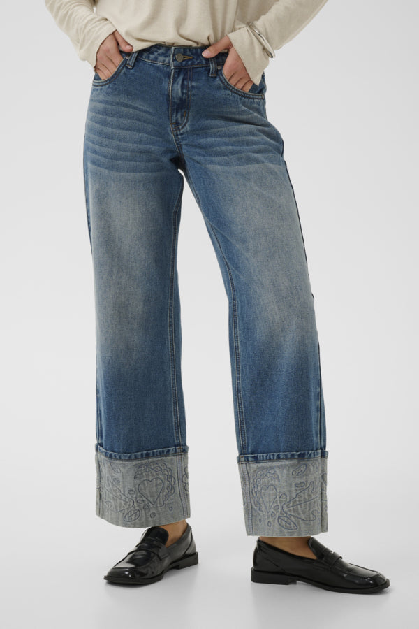 Person wearing blue jeans with a white background