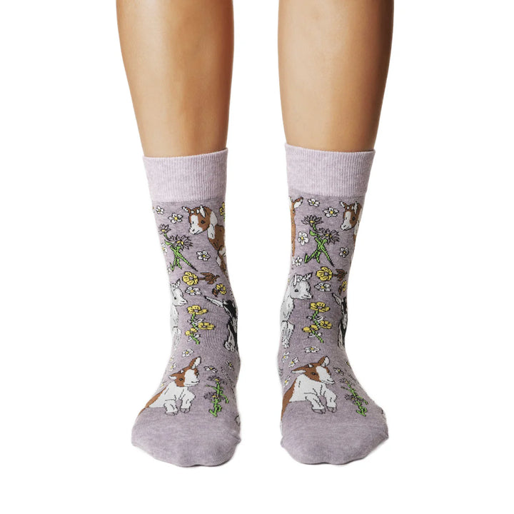 Gray socks with dog and floral pattern worn by a person on a white background