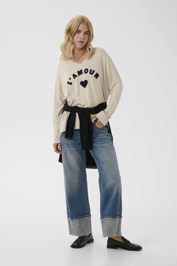 A model wearing a beige long-sleeve t-shirt with &