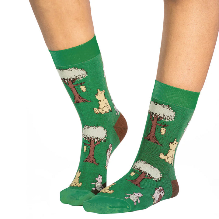Green socks with animal and tree pattern worn by a person on a white background