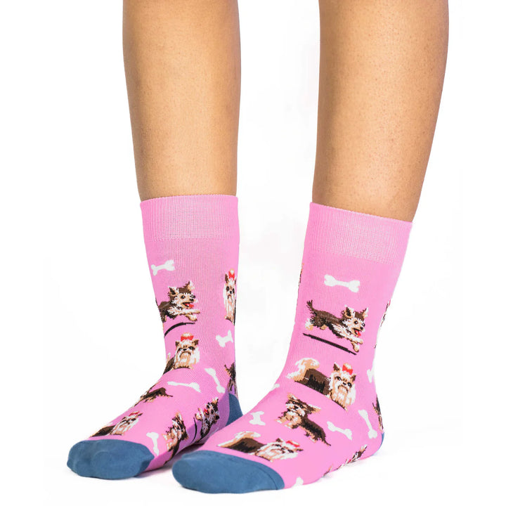 Pink socks with dog pattern worn by a person on a white background